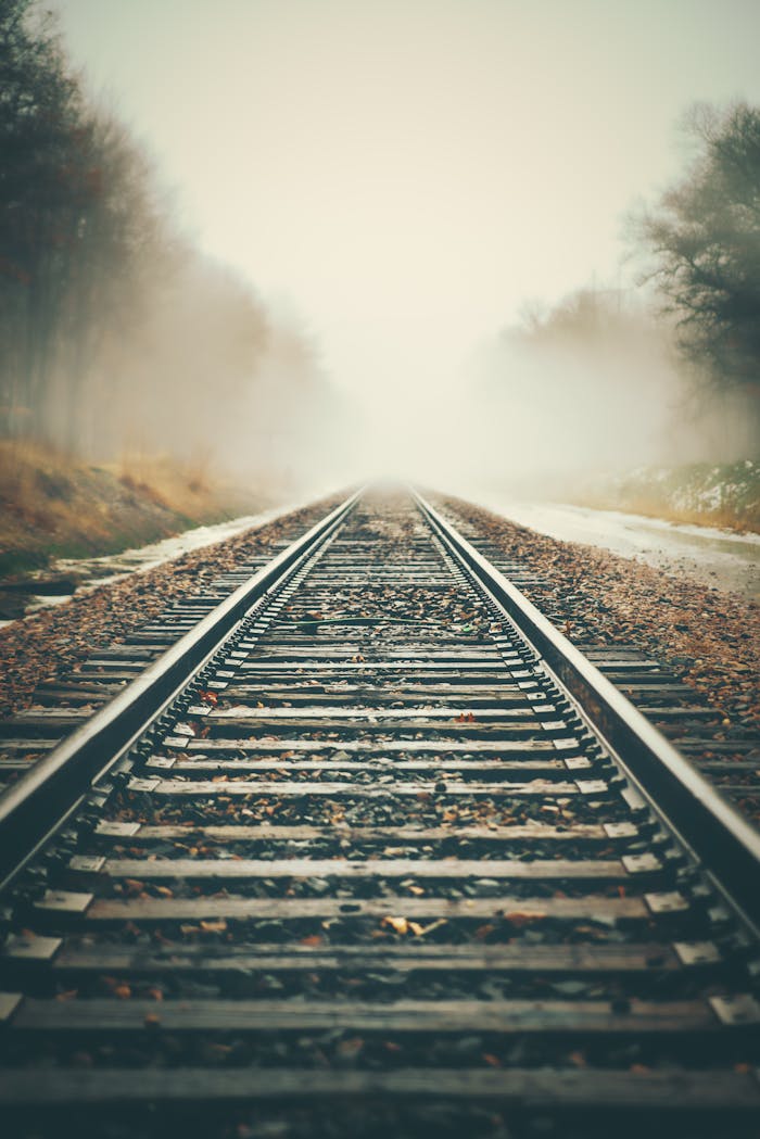 A mysterious misty railroad disappearing into fog, creating a moody perspective.