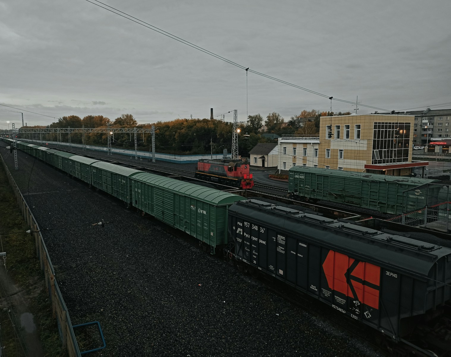 a train traveling down train tracks next to a tall building
