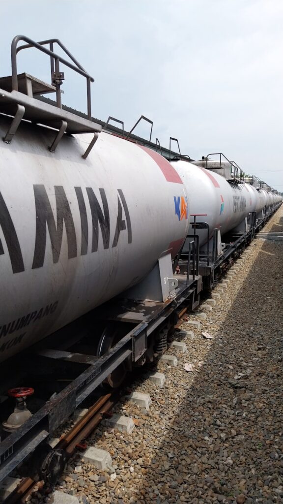 a train with a tanker car on the tracks